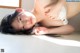 A woman laying on the floor with her hands on her stomach.
