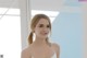 A woman in a white dress posing for a picture.