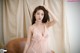 A woman in a pink lingerie posing for a picture.